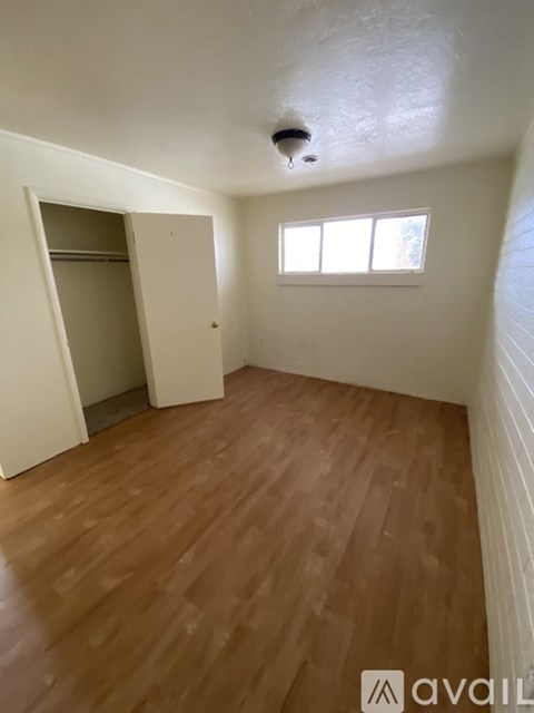 A room with wooden flooring and a window.