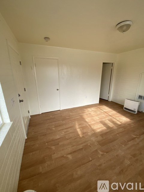 A room with wooden flooring and white walls.
