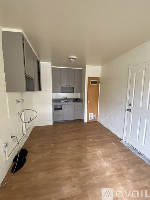 A kitchen with wooden floors and white walls.
