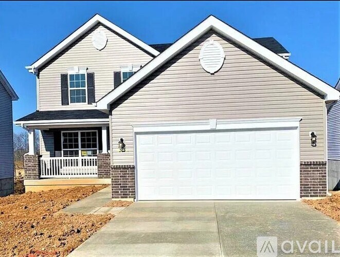 A two-story house with a garage and a driveway.