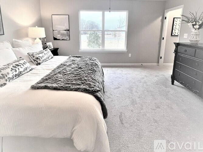 A bedroom with a large bed and a dresser.