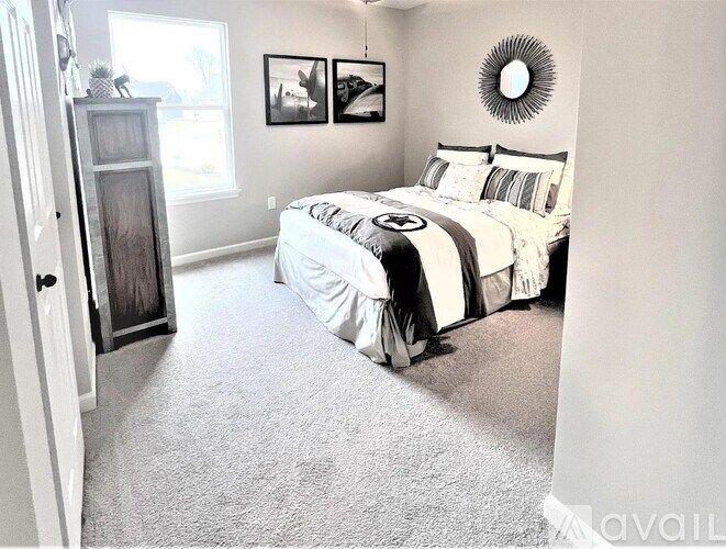 A bedroom with a bed, a dresser, and pictures on the wall.