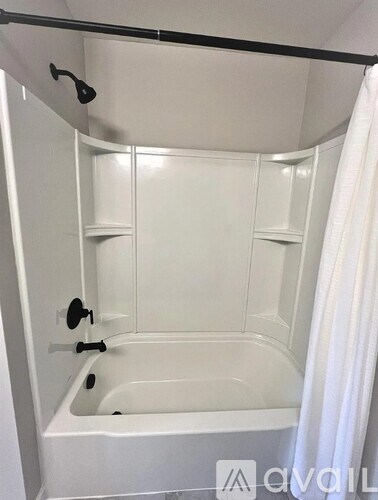 A white bathroom with a bathtub and a shower curtain.