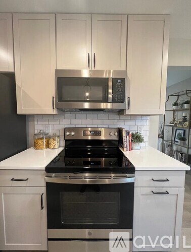 A kitchen with white cabinets and a black stove top.
