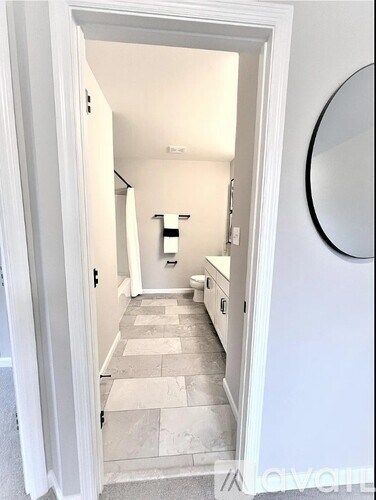 A hallway with a tiled floor and white walls.