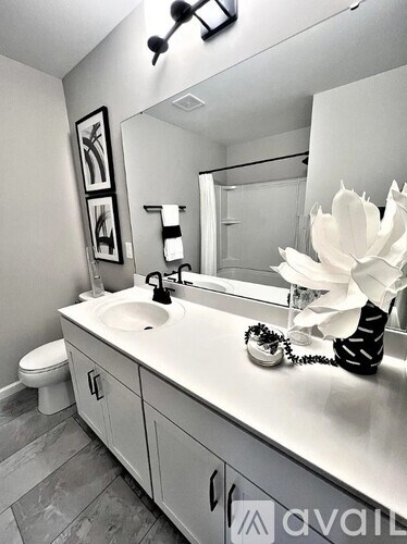 A bathroom with a white sink and a white flower.