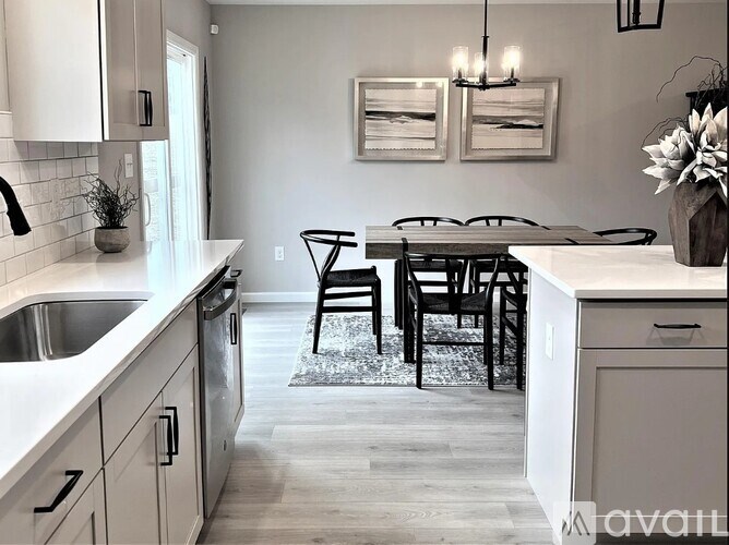 A kitchen with a table and chairs in the middle.