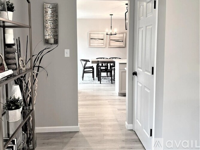 A hallway with a table and chairs in the distance.