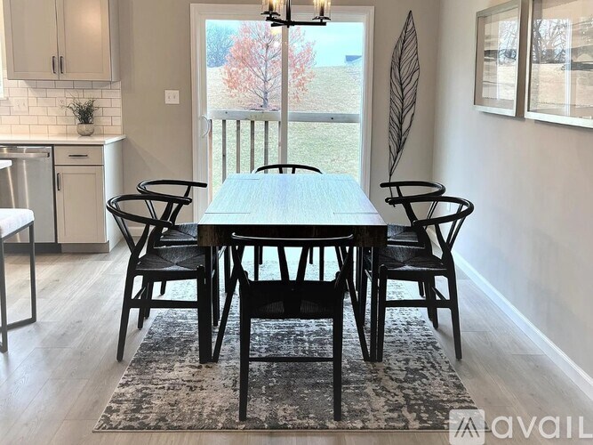 A dining room with a table and chairs.