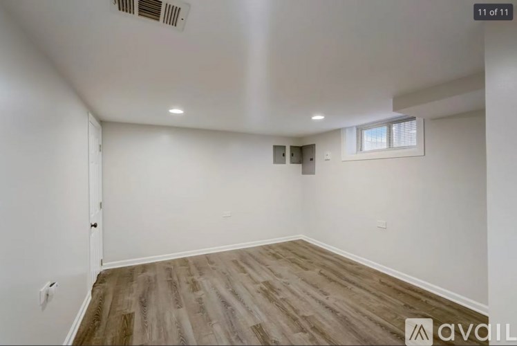 A room with wooden flooring and a window on the wall.