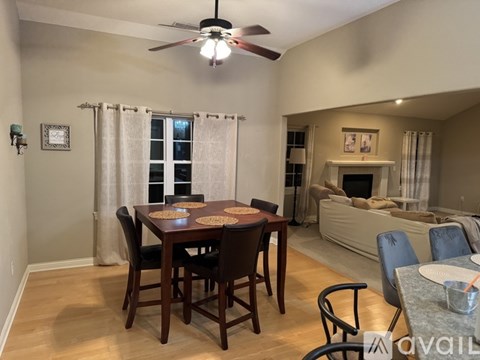 A living room with a white couch and a wooden dining table.