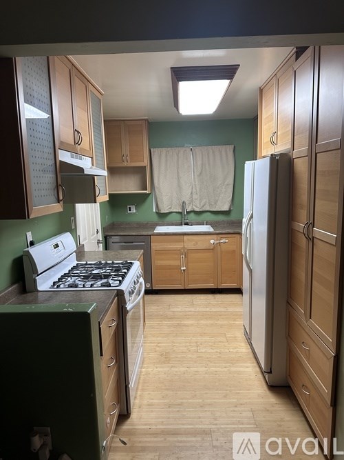 A kitchen with a white stove top oven and a white refrigerator.