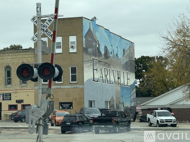 A street view of a railroad crossing with a sign that says "Earlsville".