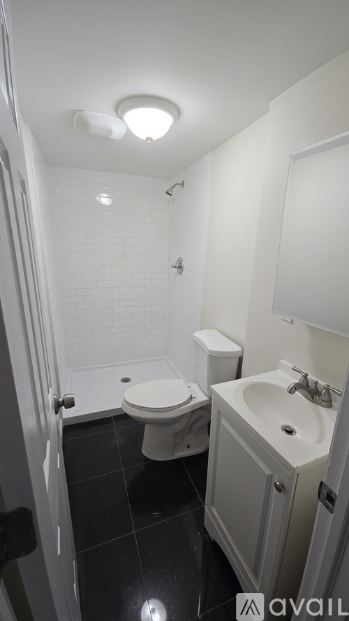 A bathroom with a toilet, sink, and shower.
