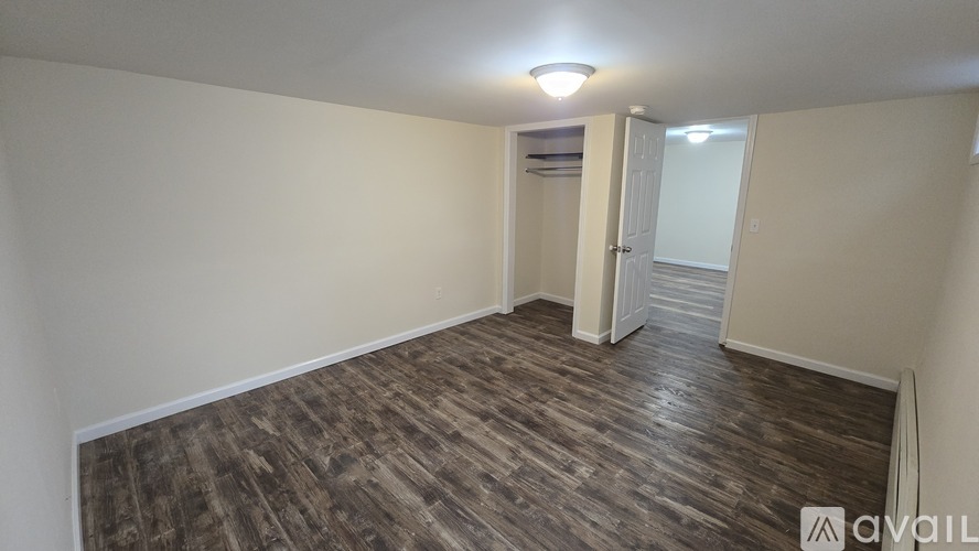 A room with wooden flooring and a white door.