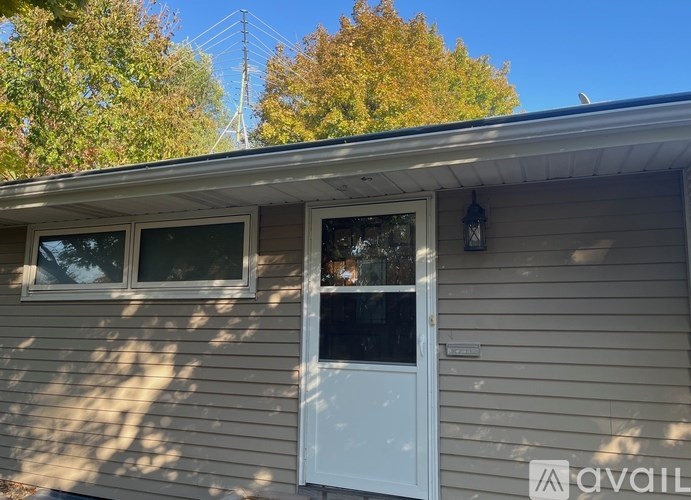 A house with a white door and windows is available for rent.