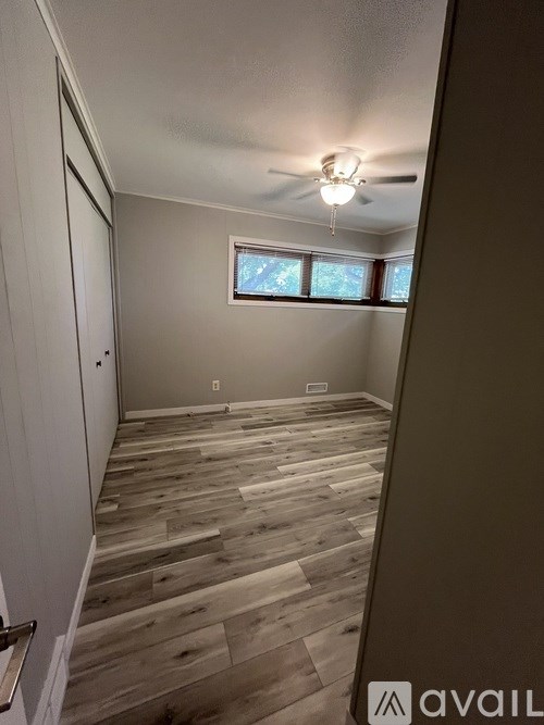 A room with wooden flooring and a window.
