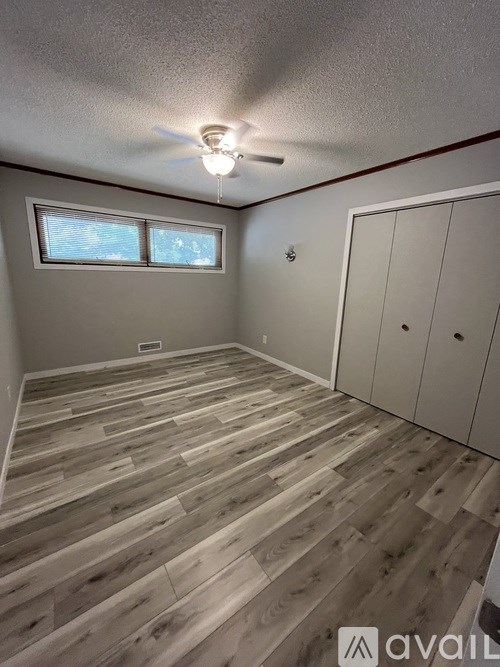 A room with wooden flooring and a ceiling fan.