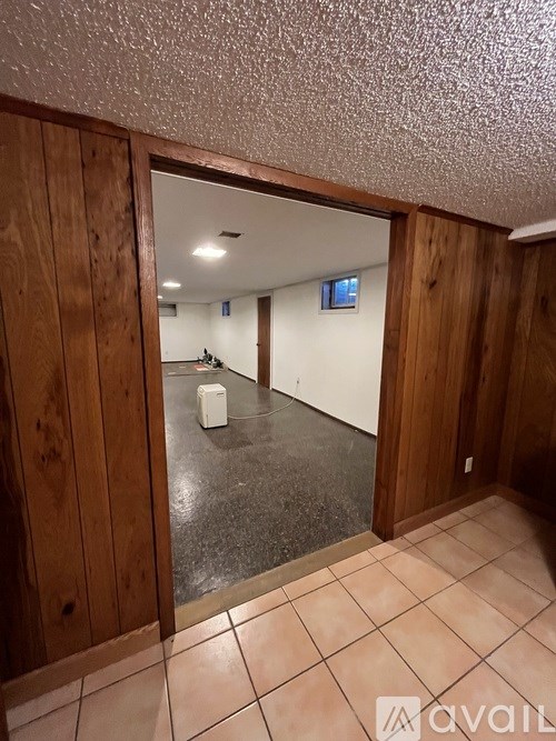 A room with wooden walls and a tiled floor.