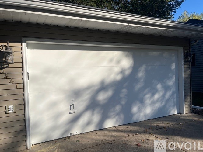 A white garage door is closed and has a small handle on the right side.