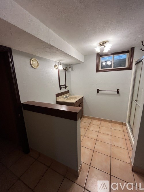 A bathroom with a brown counter and a window.