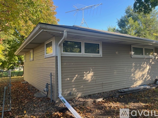A house with a grey exterior and a white roof is shown.