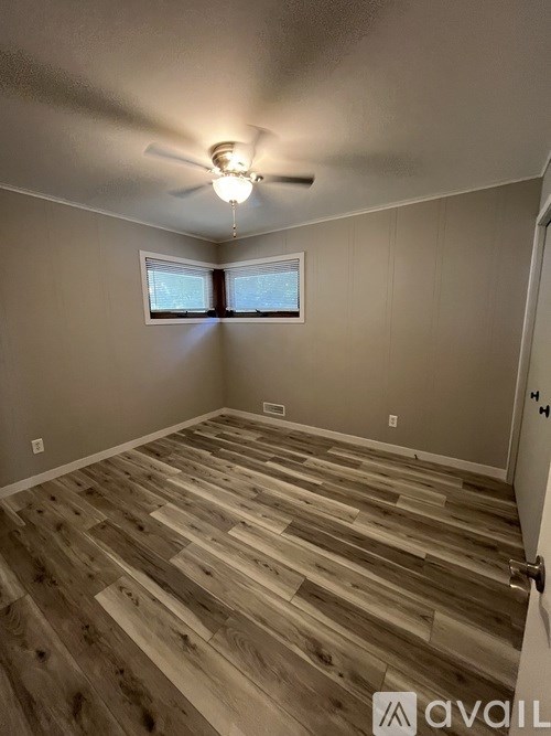 A room with wooden flooring and a ceiling fan.