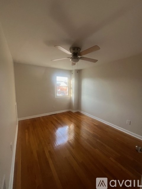 A room with wooden floors and a ceiling fan.