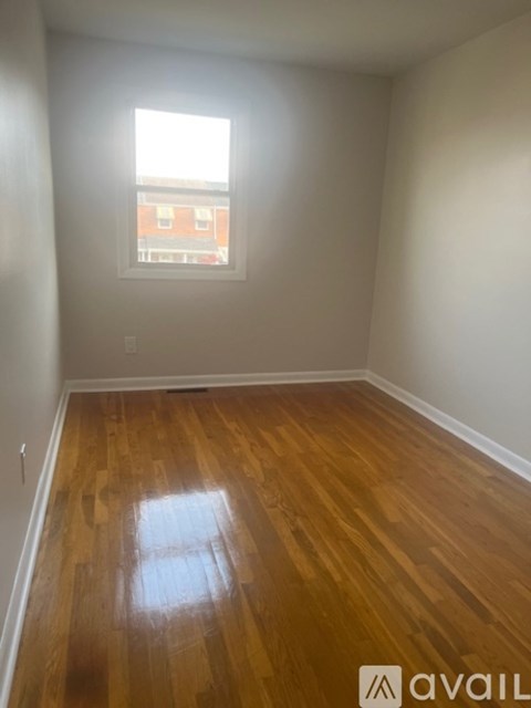 A room with wooden flooring and a window.