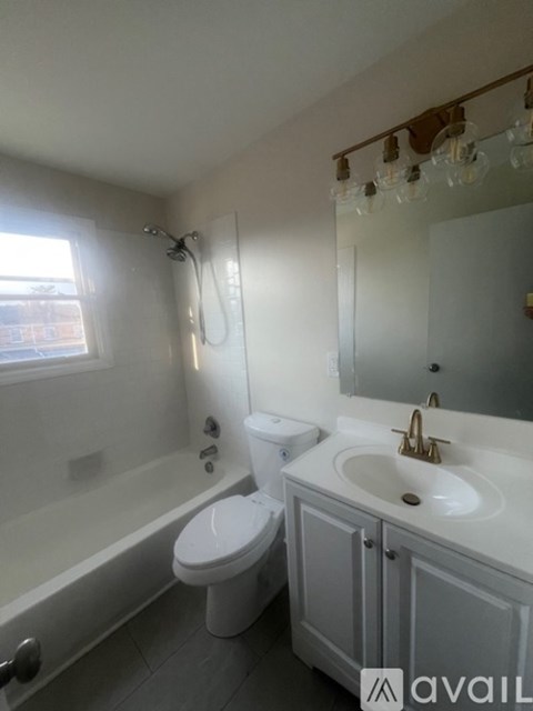 A white toilet sits next to a bathtub in a bathroom.