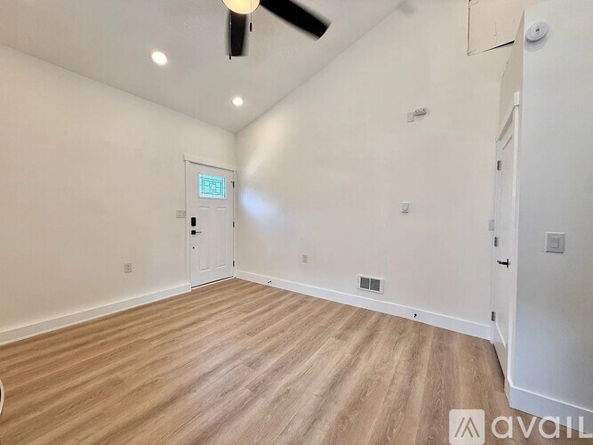 A room with wooden flooring and a white door.