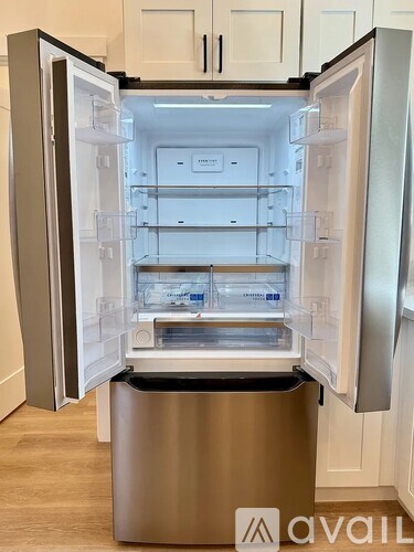 A stainless steel refrigerator with its door open and shelves visible.