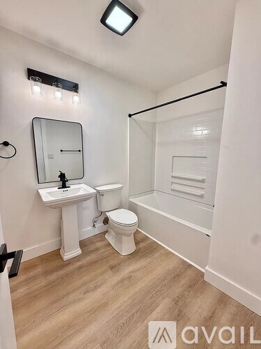 A white bathroom with a sink, toilet and mirror.