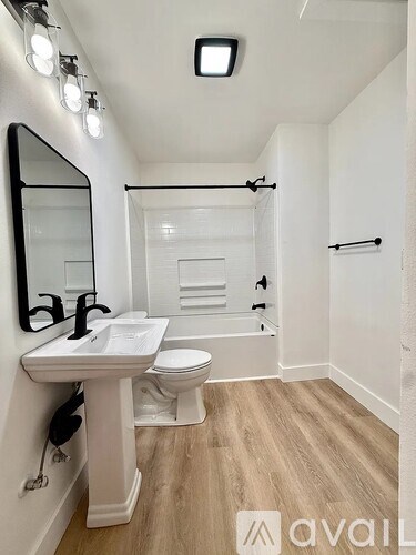 A bathroom with a sink, toilet, and bathtub.