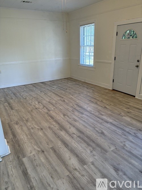 A room with wooden flooring and a white door.