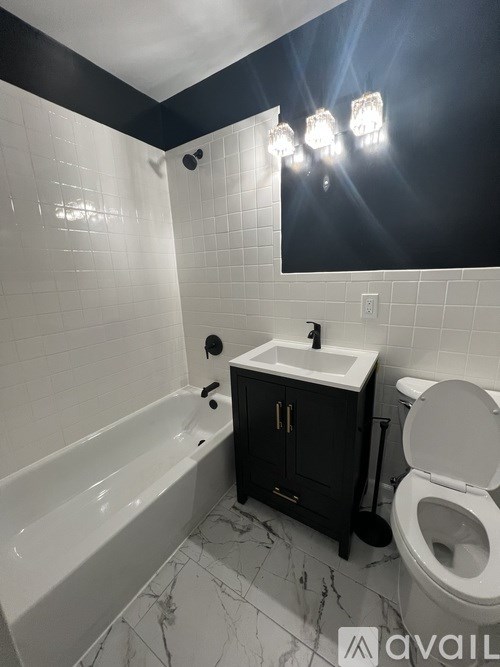 A bathroom with a white tub, sink, and toilet.