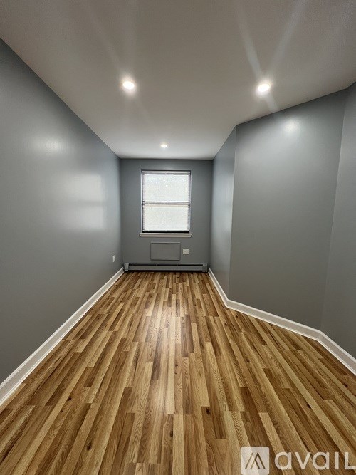 A room with wooden flooring and a window.