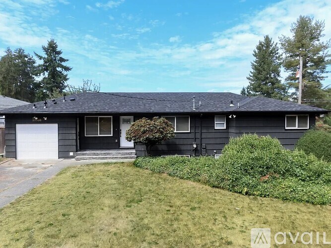 A house with a black roof and white garage door.