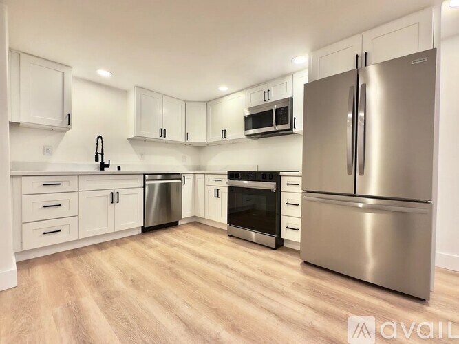 A kitchen with a refrigerator, oven, and microwave.