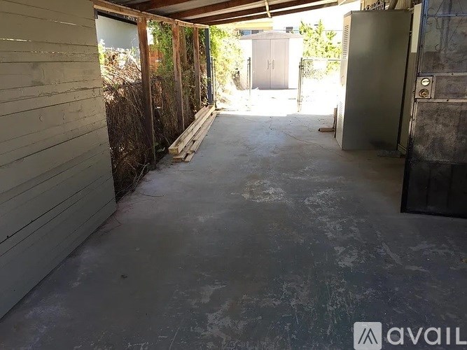 A concrete patio with a wall on one side and a door on the other.