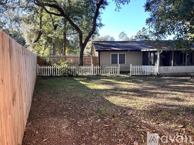 A backyard with a fence and a house in the background.