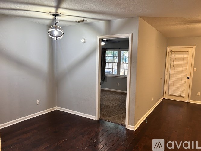 A room with a ceiling fan and a door leading to another room.
