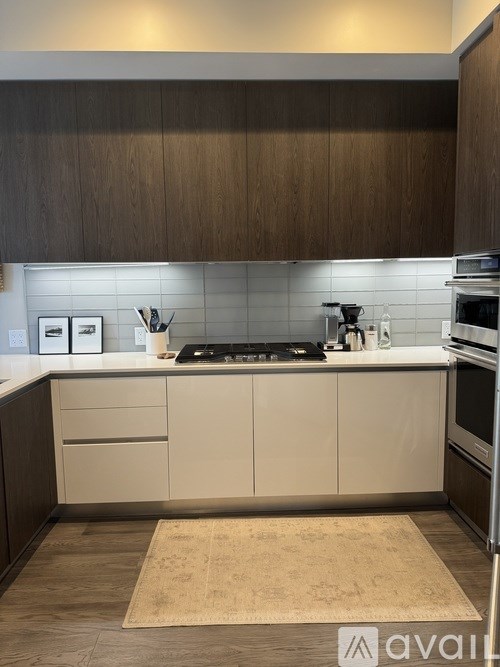 A kitchen with a white countertop and a rug on the floor.