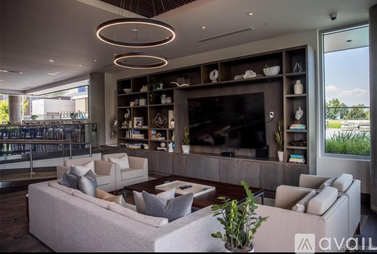 A modern living room with a large couch, a television, and a bar area.