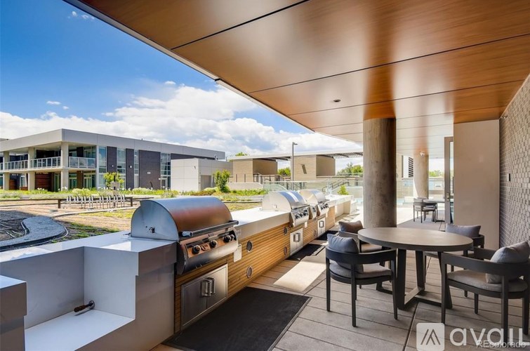 A modern outdoor kitchen area with a grill and seating area.