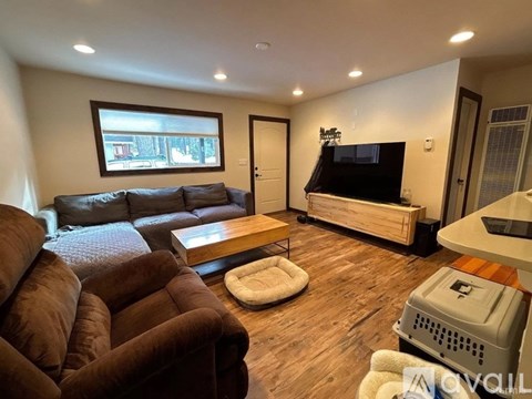 A living room with a brown couch and a flat screen TV.