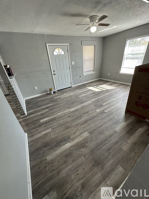 A room with wooden flooring and a white door.