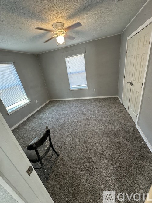 A room with a ceiling fan and a window.
