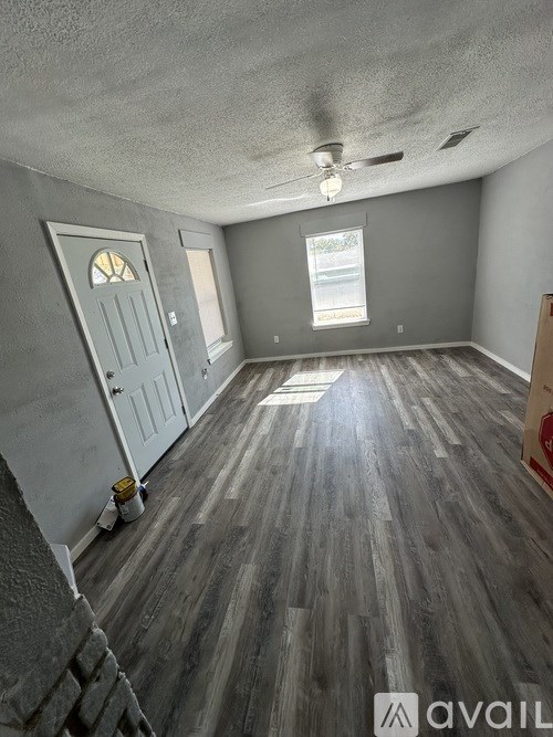 A room with wooden flooring and a ceiling fan.