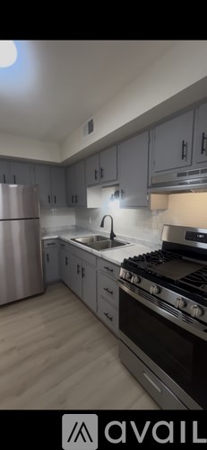 A kitchen with a stove, sink, and cabinets.